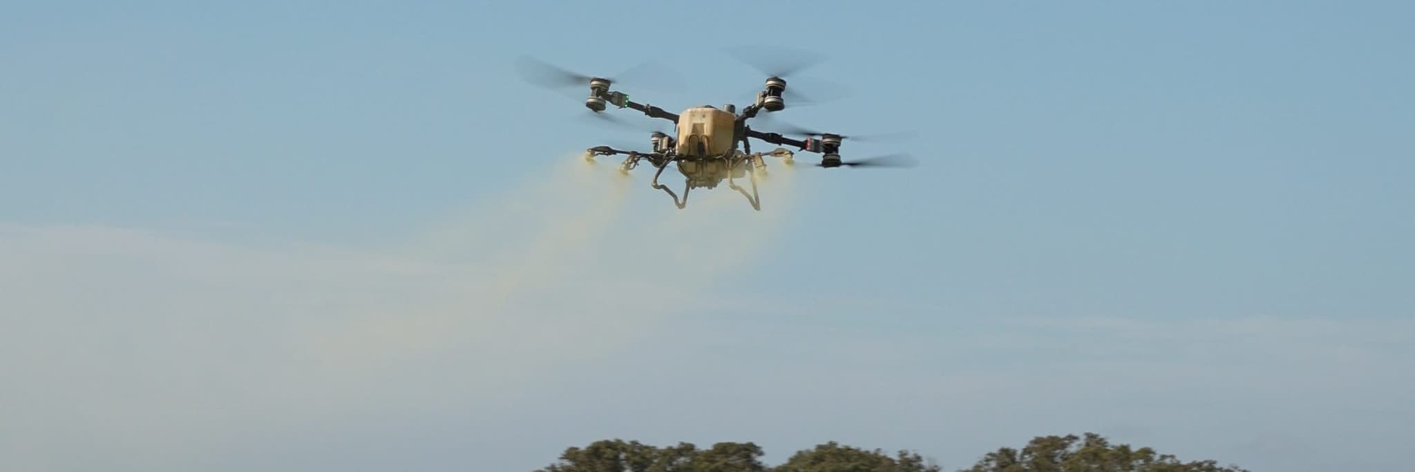 An AGX crew's spray drone laying a pass over a row crop